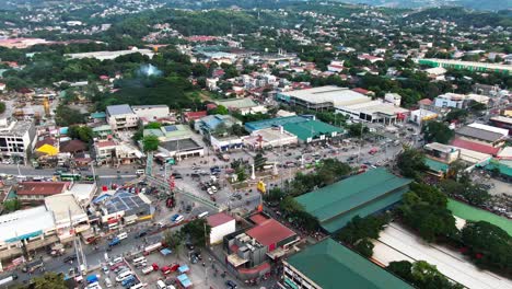 Aerial-drone-view-from-town-of-Taytay-Rizal,-busy-vehicles-driving-on-intersection
