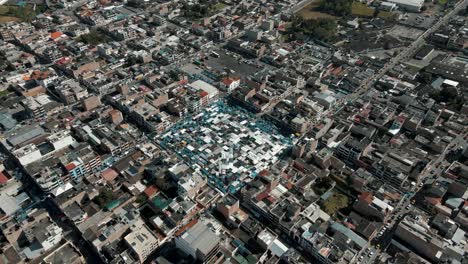 Paisaje-Urbano-De-Otavalo-Con-Plaza-De-Ponchos-Durante-El-Verano-En-Ecuador---Panorámica-Aérea