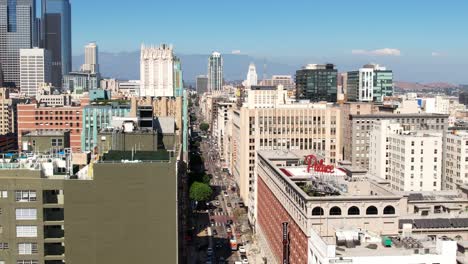 Aerial-view-descending-over-Downtown-buildings,-Los-Angeles-skyline-in-summer-sun