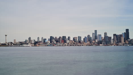 Seattle,-Washington-skyline-as-seen-from-Luna-Park-across-Elliott-Bay---time-lapse-of-cityscape-and-ferries