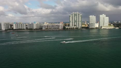 Drone-footage-of-downtown-Miami-with-speedboats-on-water-with-buildings-in-background