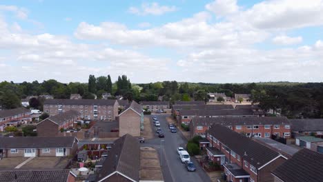 Aerial-footage-towards-the-horizon-of-trees-and-sky-revealing-homes-and-streets,-Housing-Estate-in-Norfolk,-England
