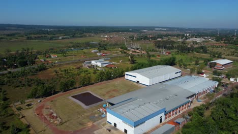 Overtake-Shot-Of-Big-Industrial-Factory-In-Green-Neighborhood-Area,-Paraguay
