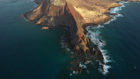 Tilt-up-drone-shot-of-brown-and-red-mountains-in-Porto-Santo,-Madeira