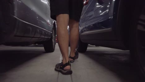 POV-to-man's-feet-while-walking-in-parking-lot-and-get-into-car-in-slowmotion