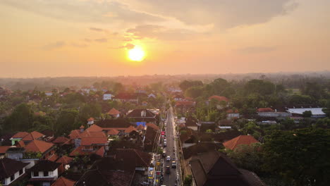 Scenic-Sunset-Over-Ubud-City-With-Street-And-Buildings-In-Bali,-Indonesia---aerial-drone-shot