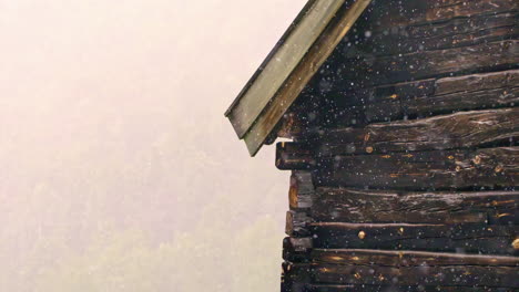 Eine-Rustikale-Hütte-In-Den-Bewaldeten-Bergen-Während-Eines-Ungewöhnlich-Frühen-Schneesturms---Zeitlupe