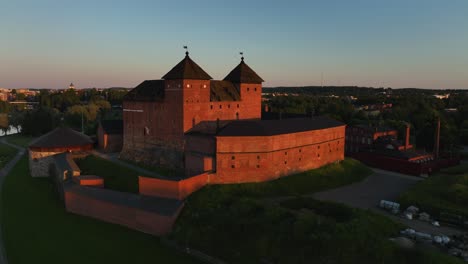 Vista-Aérea-Sobre-El-Castillo-De-Hame,-Que-Revela-El-Paisaje-Urbano-De-Hameenlinna,-Puesta-De-Sol-En-Finlandia---Aumento,-Disparo-De-Drones