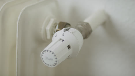 Close-up-of-a-hand-turning-up-the-temperature-of-a-radiator