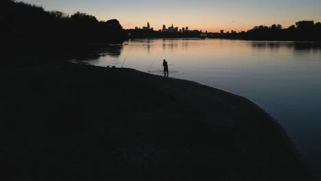 Un-Pescador-Solitario-A-Orillas-Del-Río-Vistula-Bajo-El-Resplandor-Del-Sol-Poniente-Sobre-Los-Rascacielos-De-Varsovia