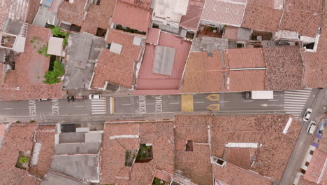 Top-down-aerial-footage-of-a-street-in-Cali,-Colombia-with-cars-moving-down