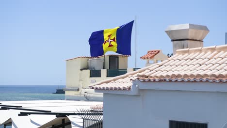 Flag-waving-on-top-of-building-in-Madeira,-Portugal