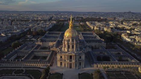 A-drone-shot-pulls-back-to-reveal-a-setting-sun-shining-on-the-Dome-Church-in-Paris,-France