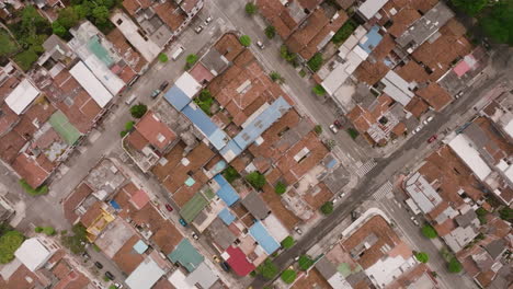 Top-down-aerial-footage-of-streets-and-neighborhoods-with-cars-driving-in-the-city-of-Cali,-Colombia