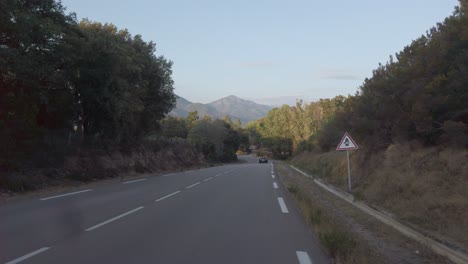 Driving-a-car-on-the-costal-road-of-Corsica-during-sunset-light
