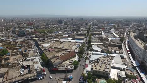 Eine-Luftaufnahme-Der-Stadt-Erbil-Mit-Der-Alten-Zitadelle-Von-Erbil-Und-Dem-Garten-Gegenüber-Dem-Schloss-Mit-Wasserfontänen-Und-Dem-Beliebten-Markt-18