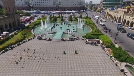 Eine-Luftaufnahme-Der-Stadt-Erbil-Mit-Der-Alten-Zitadelle-Von-Erbil-Und-Dem-Garten-Gegenüber-Dem-Schloss-Mit-Wasserfontänen-Und-Dem-Beliebten-Markt-17