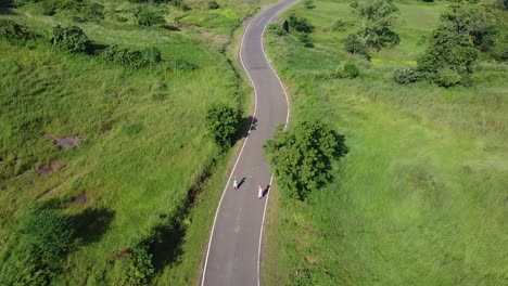 Menschen,-Die-Auf-Einer-Kurvenreichen-Straße-Durch-Eine-üppige-Wiese-In-Trimbakeshwar,-Nashik,-Indien,-Gehen