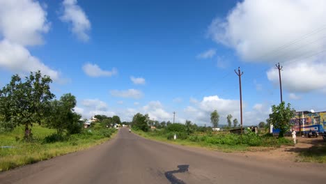 Car's-POV-Driving-On-The-Scenic-Road-With-White-Clouds-In-The-Sky-At-Daytime