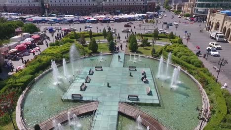 Eine-Luftaufnahme-Der-Stadt-Erbil-Mit-Der-Alten-Zitadelle-Von-Erbil-Und-Dem-Garten-Gegenüber-Dem-Schloss-Mit-Wasserfontänen-Und-Dem-Beliebten-Markt-5