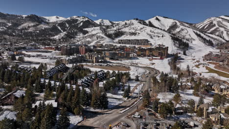 Park-City-Utah-Aerial-v65-flyover-canyons-village-resort-surrounded-by-wild-nature,-capturing-beautiful-scenic-mountainscape-covered-in-snow-on-a-sunny-day---Shot-with-Mavic-3-Cine---February-2022