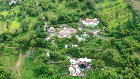 Aerial-circling-dense-greenery-surrounding-a-luxury-white-dome-villa-in-Lombok-Indonesia
