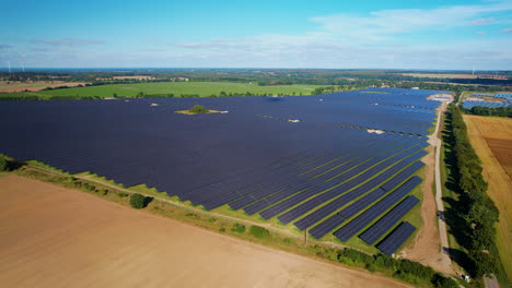 Solar-panel-farm-in-fields-of-Poland,-Europe-in-aerial-approaching-view
