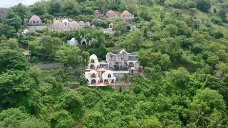 White-dome-villa-hotel-on-mountain-hill-in-Mentigi-Bay-Lombok-Indonesia,-aerial