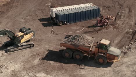 Birds-eye-view-of-a-dump-truck-full-of-dirt-traveling-a-construction-site