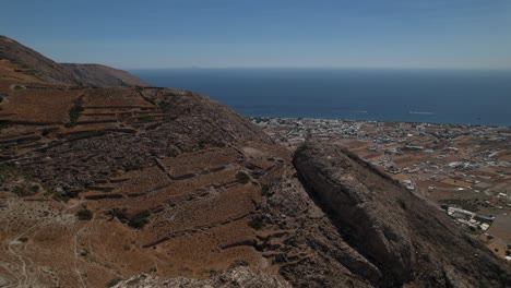 Luftbild-Rund-Um-Kahle-Berge-Auf-Der-Insel-Santorini,-Im-Sonnigen-Griechenland---Drehen,-Zurückziehen,-Drohne-Erschossen