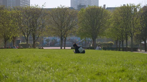 Junger-Mensch-Genießt-Sonnigen-Tag-Im-Pariser-Stadtpark,-Rückansicht