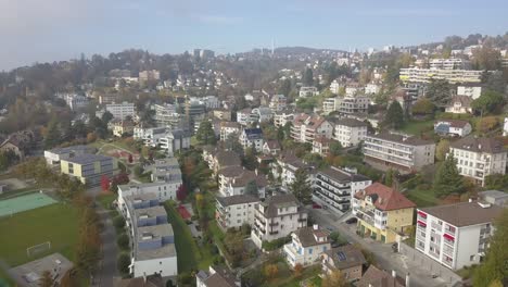 Drone-panning-aerial-shot:-Lausanne,-residential-area-of-the-city,-houses-and-buildings-surrounded-by-gardens,-urban-environment,-Switzerland,-Vaud