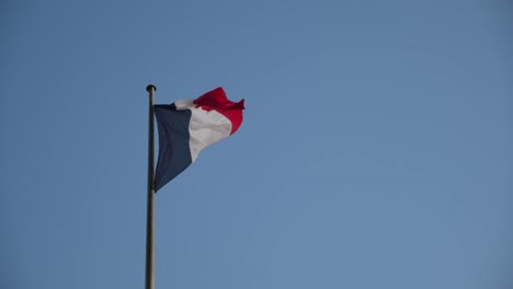 Nationalflagge-Von-Frankreich-Weht-Bei-Starkem-Wind-Gegen-Blauen-Himmel,-Zeitlupe