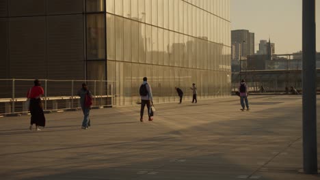 People-walking-in-Paris-business-district-during-early-morning-hours-with-golden-sunrise