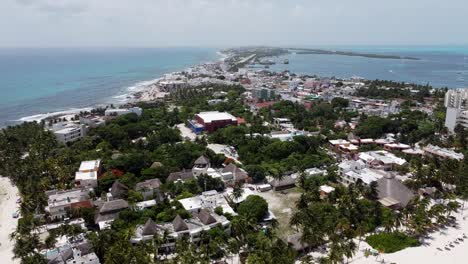 Aerial-drone-backward-moving-shot-over-the-houses-and-resorts-in-southern-tip-of-Isla-Mujeres-island-in-Quintana-Roo,-Mexico