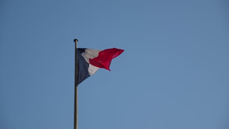 Bandera-Francesa-Ondeando-Contra-El-Cielo-Azul-En-París,-Francia