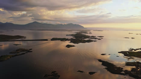 Aerial-view-of-the-Atlantic-Ocean-Road,-surrounded-by-reflecting-water,-calm,-summer-evening-in-Norway