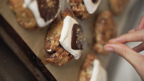 Vertical-Shot---Sprinkling-Graham-Powder-On-Top-Of-Freshly-Baked-S'more-Cookies