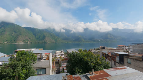 Shot-from-over-residential-houses-of-lake-Atitlan,-Guatemala,-Central-America-surrounded-by-volcanic-mountains-at-daytime