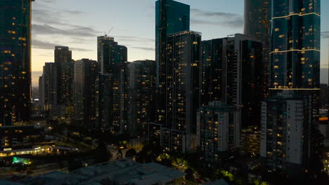 Beautiful-dusk-aerial-accent-looking-at-Melbourne-city-skyscrapers-and-dusk-lights-glowing-on-stunning-evening