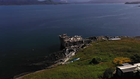 Aerial-view-of-a-old-broken-boathouse,-summer-day-in-Norway---reverse,-tilt,-drone-shot