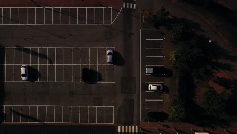 Vista-Aérea-Sobre-Los-Autos-En-Un-Estacionamiento,-Durante-El-Amanecer---Arriba,-Disparo-De-Drones