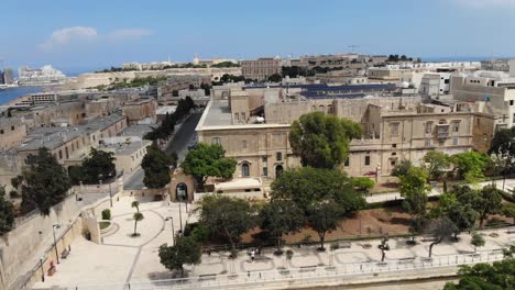 Aufschlussreiche-Luftdrohnenansicht-Der-Befestigungen-Des-Argotti-Botanischen-Gartens-Mit-Valletta-Im-Hintergrund-In-Floriana,-Malta