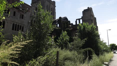 Abandoned-historic-City-Methodist-Church-in-Gary,-Indiana-with-gimbal-video-walking-forward-on-the-side-in-slow-motion