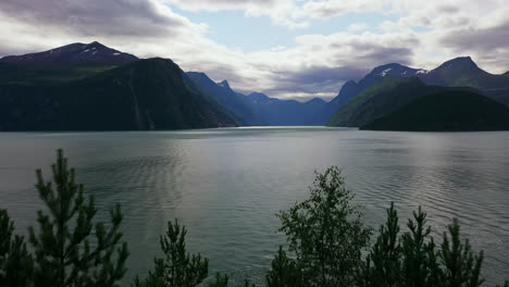 Aerial-view-revealing-the-Geiranger-Fjord,-partly-sunny-summer-day-in-Norway---rising,-drone-shot