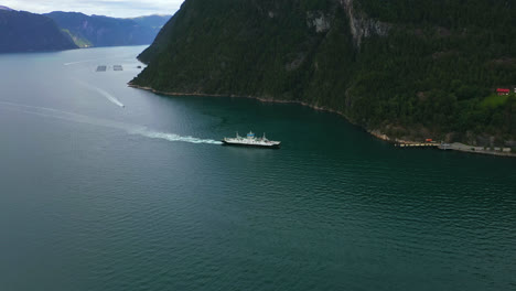 Aerial-view-of-a-car-transfer-ferry-arriving-the-Liabygda-Feriekai-in-Norway---pan,-drone-shot