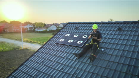 Digitally-equipped-technician-installs-solar-panel-on-residential-house