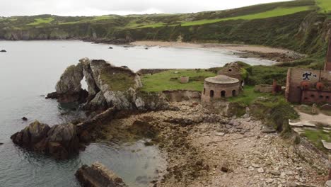 Porth-Wen-aerial-rising-back-view-abandoned-Victorian-industrial-brickwork-factory-remains-on-Anglesey-eroded-coastline