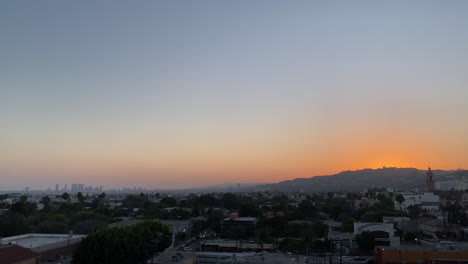 Sunset-Sinking-Below-Hills-Over-Distant-Village-In-Los-Angeles,-California---wide