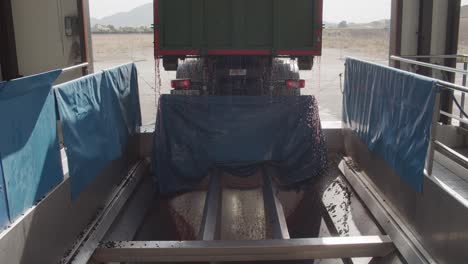 Toma-Frontal-De-Un-Camión-Descargando-Jugo-De-Uva-En-Una-Tolva-En-Una-Bodega-Para-La-Producción-De-Vino-En-Cámara-Lenta-60fps